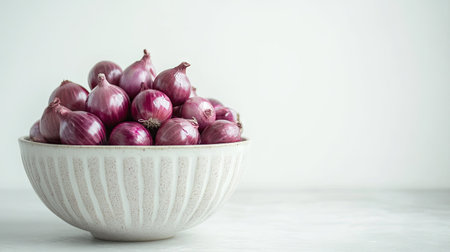 A bowl filled with glossy red onions, placed against a white background for a clean, fresh look.の素材