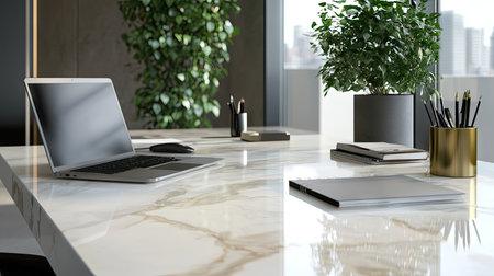 A modern marble desk with a laptop, a potted plant, and stylish stationery on topの素材