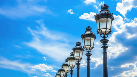 A row of street lamps extending into the distance under a brilliant blue sky, creating a sense of depthの素材