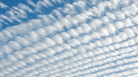 White clouds forming intricate patterns in a bright and peaceful blue summer sky.の素材