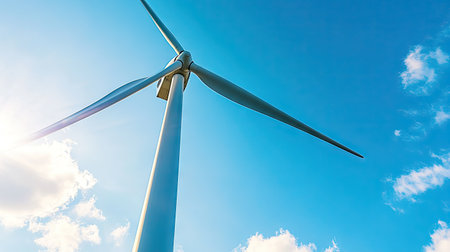 Close-up of a traditional Dutch windmill with a modern wind turbine visible in the background, under a bright blue skyの素材