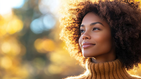 A woman with rich, curly hair, standing outdoors in the fall, wearing a cozy sweater and looking off into the distanceの素材