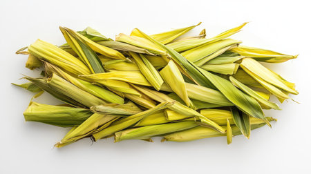 A pile of sweet corn cobs, neatly arranged and isolated on a white background.の素材