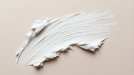 A smear of white beauty cream on a neutral background, showing the smoothness and spreadability of the product.の素材