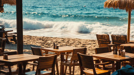 A rustic beach caf scene with large wooden tables and comfortable chairs, with the waves gently lapping the shore.の素材