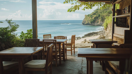 A casual yet elegant beach caf with wooden tables and cushioned chairs, with a stunning view of the ocean horizon.の素材