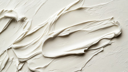 A delicate smear of white beauty cream on a soft background, emphasizing the texture and smoothness of the product.の素材