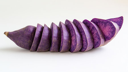 A whole purple sweet yam with thin, even slices arranged in a fan shape around it, isolated on white.の素材