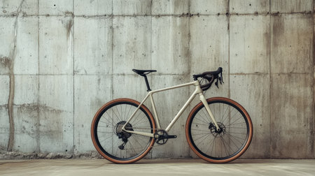 A minimalist gravel bike parked in front of an industrial concrete wall.の素材