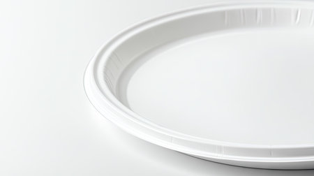 A close-up of a white plastic disposable plate, isolated on a plain background, highlighting its smooth surface.の素材