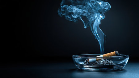 Smoke rising elegantly from a cigarette in a simple ashtray, set against a dark background.の素材