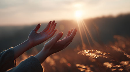 Feminine hands stretching outward with golden hour sun illuminating fine details, a peaceful evening momentの素材