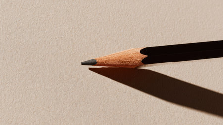 Minimalist composition of a pencil forming a diagonal line across a neutral beige backgroundの素材