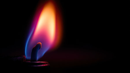 Close-up of a lighter flame in pitch-black background, focused on flame shape and color gradientの素材