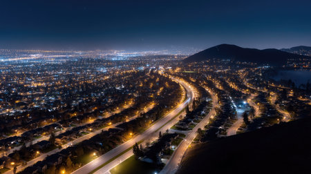 Panoramic nighttime aerial view of an urban city, with rows of streetlights lighting up the streets, creating a beautiful contrast with dark surroundingsの素材