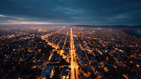 Panoramic nighttime aerial view of an urban city, with rows of streetlights lighting up the streets, creating a beautiful contrast with dark surroundingsの素材