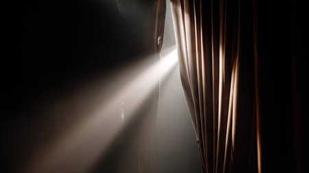 Spotlight beaming through a narrow curtain opening as anticipation builds before the showの素材