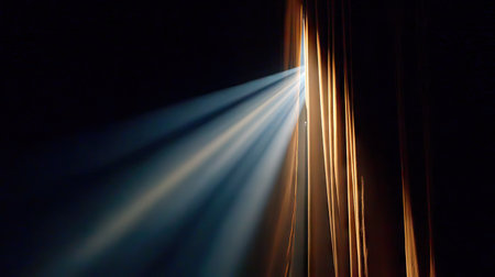 Spotlight beaming through a narrow curtain opening as anticipation builds before the showの素材