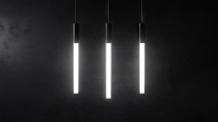 Hanging fluorescent bulbs glowing in the dark with visible wiring and soft ambient shadowsの素材
