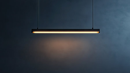 Minimalist photo of a single fluorescent light bulb hanging in the center on a gray backgroundの素材