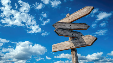 Multi-arrow wooden signpost with blank signs, dramatic sky with scattered clouds in the background, symbolizing choices or journeyの素材