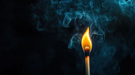 Burning wooden match separated from darkness, glowing flame and smoke rising, representing fire, spark, and beginningの素材
