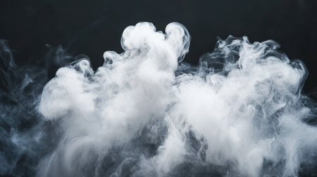 Isolated puff of white smoke rising in wispy curls against a black background, highlighting the elegance of its airy texture.の素材