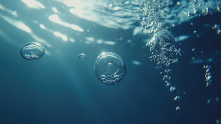 Close-up of air bubbles suspended in fresh blue water, moving upward in a pattern with soft ripples and natural lighting.の素材