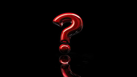 A red question mark symbol placed on a glossy black surface with dramatic lightingの素材