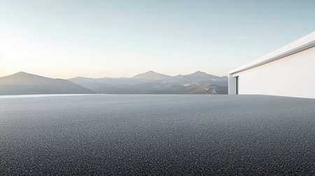 A smooth asphalt road outside a minimalist white building, with mountains visible in the distance.の素材