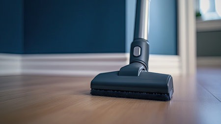 A detailed shot of a cordless vacuum cleaning along the edge of a room's baseboard.の素材