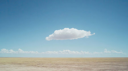 A clear sky with a single fluffy white cloud drifting across the horizon.の素材