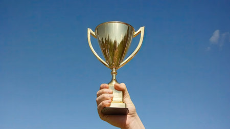 A victorious business leader raising a trophy during a corporate awards event, capturing the moment of achievement.の素材