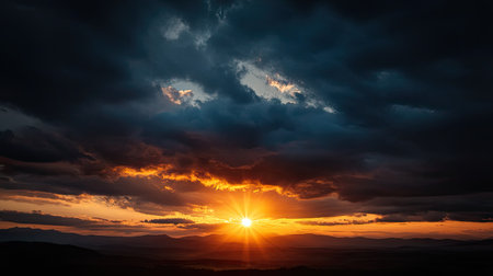 A breathtaking sunset over a mountain range features striking clouds and warm sunlight. The atmosphere creates a tranquil scene perfect for nature lovers and adventurers.の素材