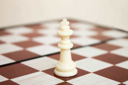 White plastic chesspiece the king on the chessboard closeupの写真素材