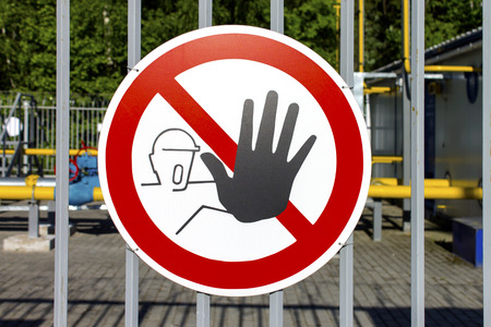 Sign stop, dangerous for life. Industrial object and metal barrier on background