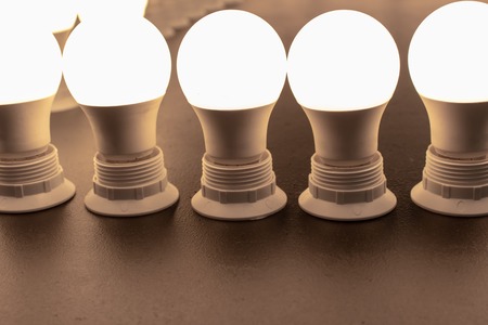 Many turned on, lighted bulbs with lampholders close upの写真素材