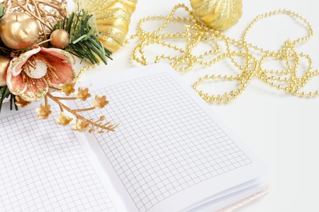 Romantic luxury Christmas and New Year decoration, golden balls, beads, opened day planner, diary on...