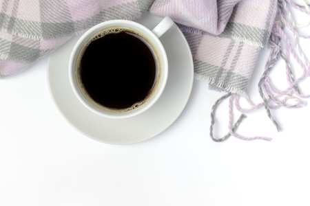White ceramic cup of coffee and pink knitted plaid on white with copy space.の写真素材