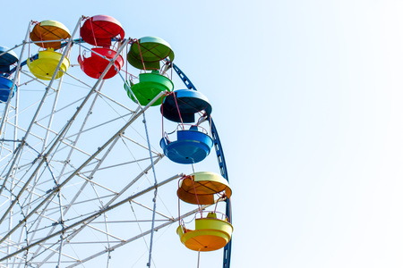 Cropped big colorful Ferris wheel with blue sky behind.の写真素材