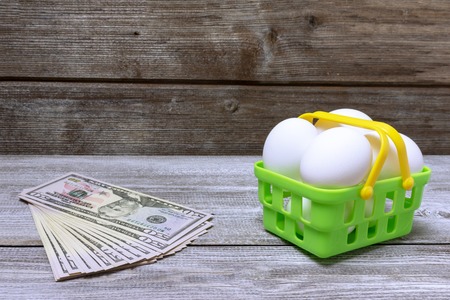 Shopping cart and money on vintage wooden background.の写真素材