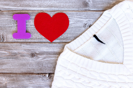 Sign i love made of letter and red heart and white female sweater, pullover on vintage wooden...