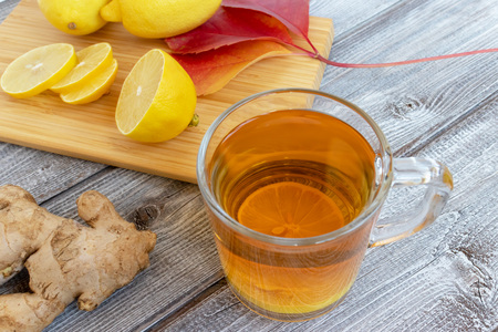 Ginger tea with lemon on a wooden table and pieces of diced lemon.の写真素材