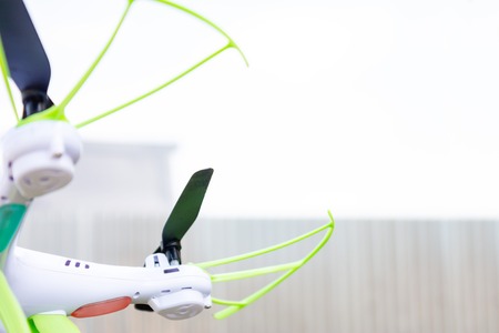 White quadcopter drone flying against the sky.