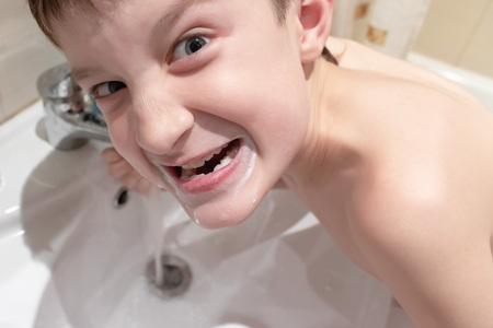 Boy making grimace in the bathroom during daily morning routine.
