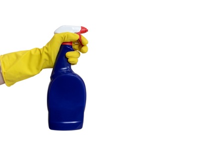 Hand in yellow rubber glove holding a blue cleaning spray bottle close up isolated on white with...