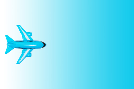 Plastic modern toy plane on blue gradient background. Travel, journey and flight concept.の写真素材