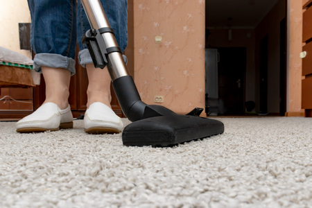 Cleaning carpets with vacuum cleaner, housewife using a vac home routine.の写真素材