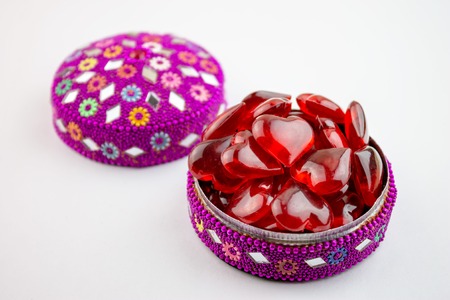 Colorful jewelry box full of red hearts on white bacground - valentine day concept.