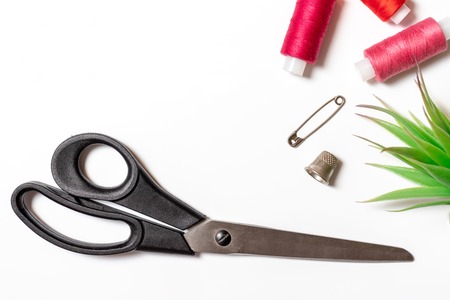 Sewing accessories - thread coil, sciccors, pins and thimble on white background - trendy design layout for hobby and DIY such as dressmaking ebroidery and needlework with copy space.の写真素材